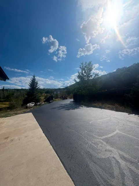 Newly paved asphalt driveway with dark finish and proper slope for drainage